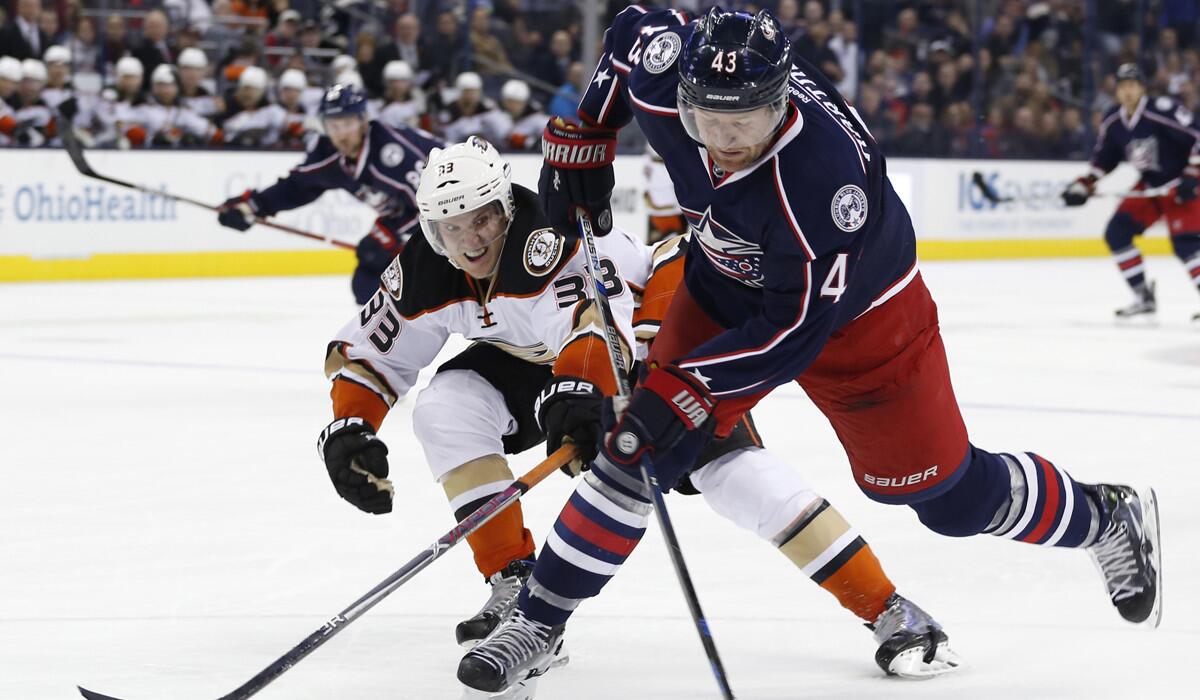 Columbus Blue Jackets' Scott Hartnell, right, shoots the puck as Ducks' Jakob Silfverberg defends during the second period on Wednesday.