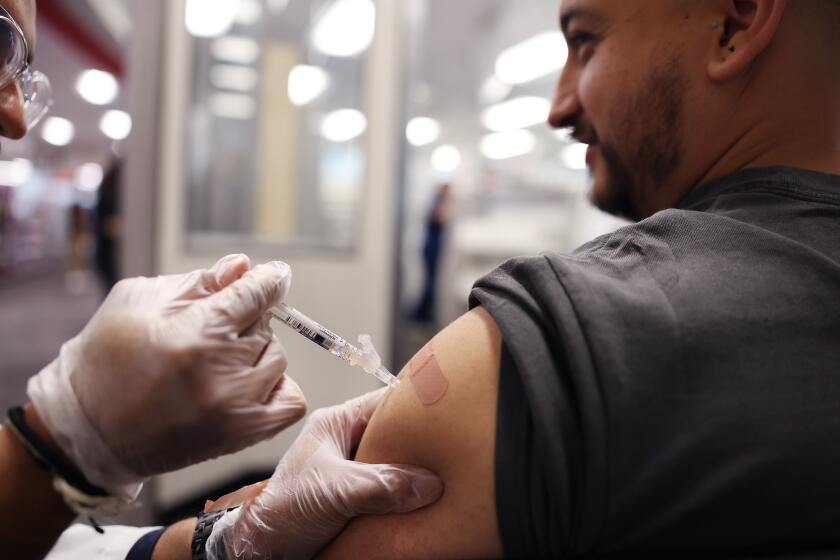 HUNTINGTON PARK-CA-AUGUST 28, 2024: Brandon Guerrero, 34, of Compton, receives both a flu and COVID-19 vaccine at CVS in Huntington Park on August 28, 2024. (Christina House / Los Angeles Times)