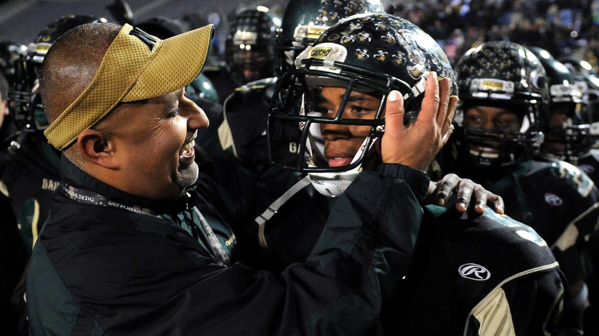 Narbonne Coach Manuel Douglas, left, hugs Tray Boone after the running back scored six touchowns in a win over Carson in the City Section championship game in 2011. He's the new coach at St. Bernard.