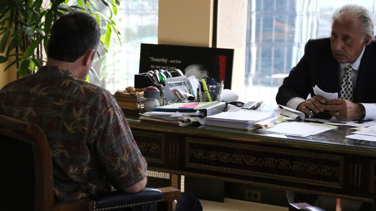 Attorney Michael Green, right, sits with his client, the former Hawaii Emergency Management Agency employee who sent a false missile alert last month, during an interview with reporters on Friday in Honolulu. The man spoke on condition of anonymity.