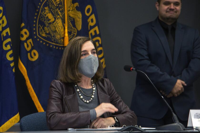 Oregon Gov. Kate Brown attends a news conference Tuesday, Nov. 10, 2020, in Portland, Ore. Brown and Oregon health officials warned Tuesday of the capacity challenges facing hospitals as COVID-19 case counts continue to spike in the state. (Cathy Cheney/Pool Photo via AP)