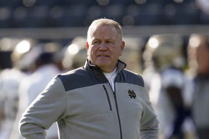 Notre Dame head coach Brian Kelly watches during warmups before an NCAA college football game against Navy in South Bend, Ind., Saturday, Nov. 6, 2021. (AP Photo/Paul Sancya)