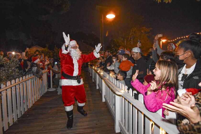 Santa walks down the boardwalk toward Templars Hall for the Tree Lighting Ceremony. 