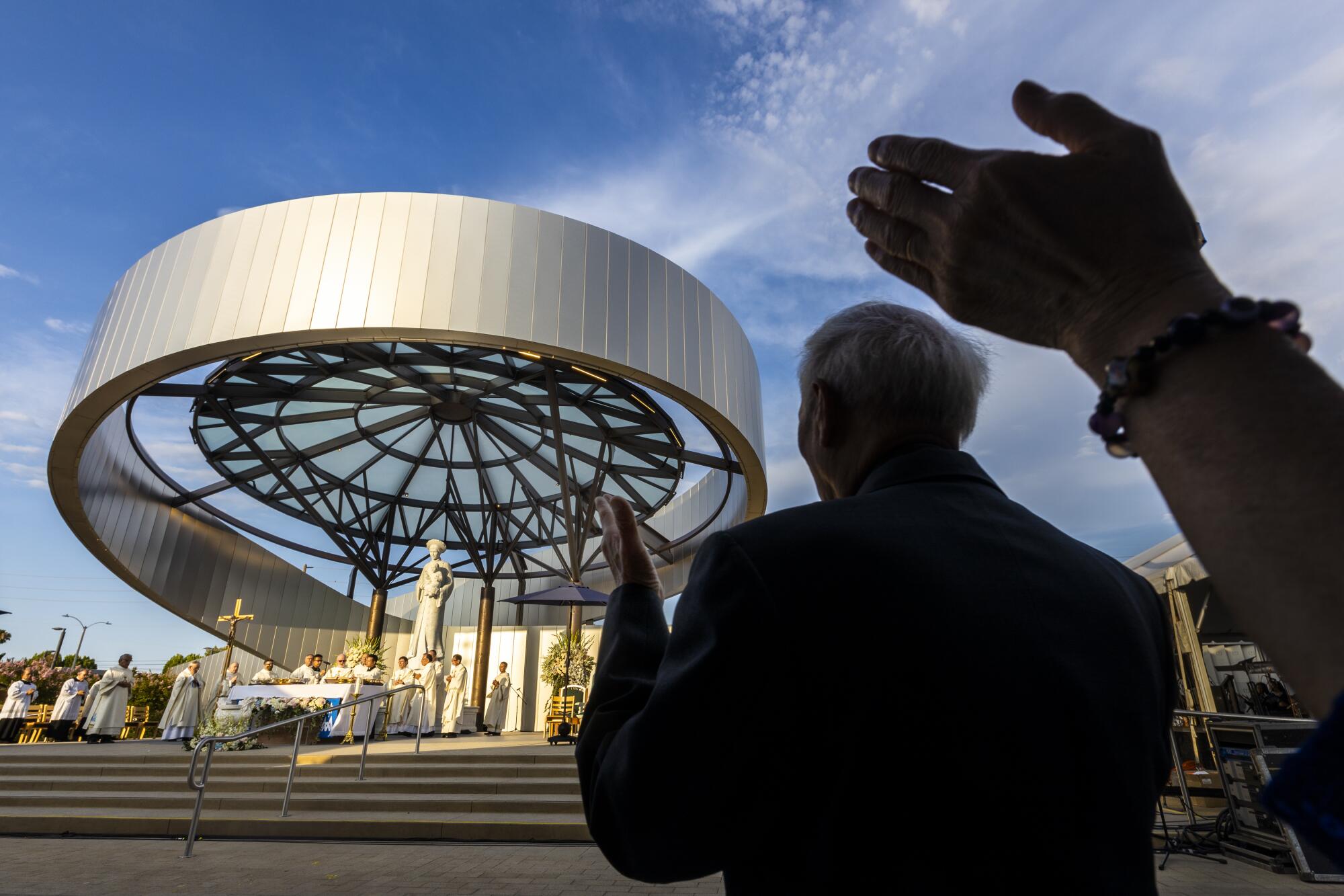 Catholics raise they hands during the blessing of the Eucharist during Mass.