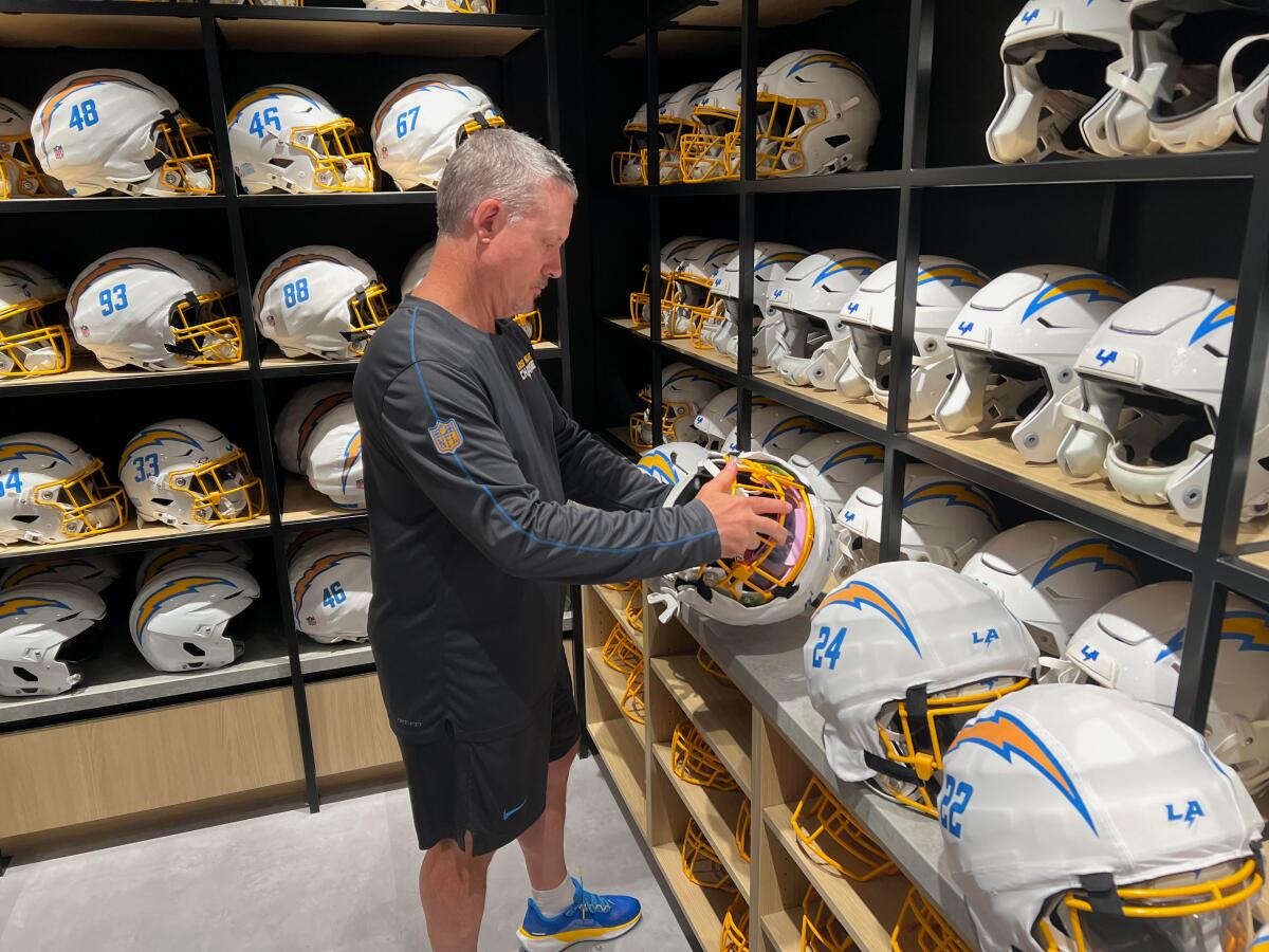 Chris Smith, director of equipment operations for the Chargers, inspects helmets at the team’s practice facility.