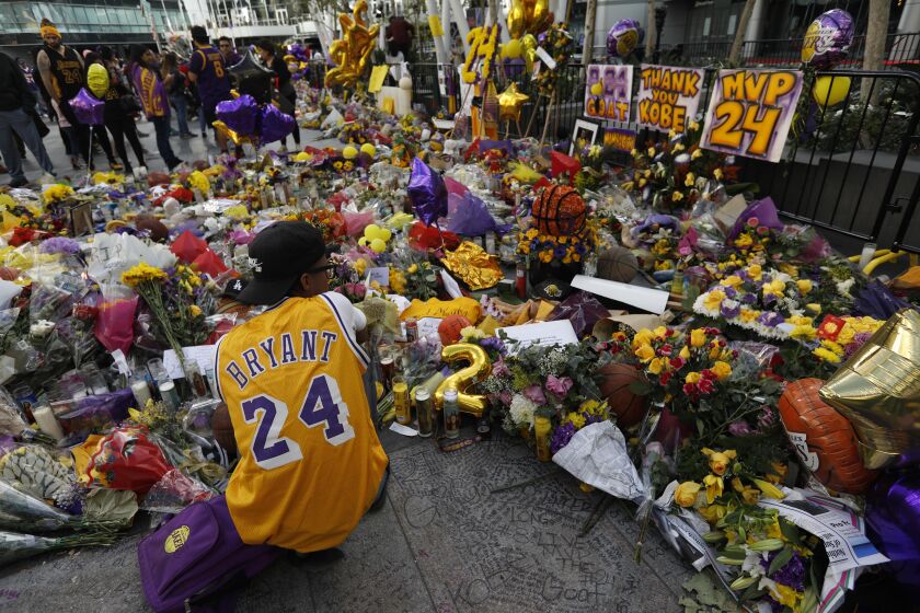 LOS ANGELES, CA - JANUARY 29, 2020 - Los Angeles resident Xavier Davenport, 32, pays his respects to Kobe Bryant at a makeshift memorial for the Lakers star at LA Live in downtown Los Angeles on January 29, 2020. “I saw him three times a week. That’s more than my biological father,” Davenport said. (Genaro Molina / Los Angeles Times)