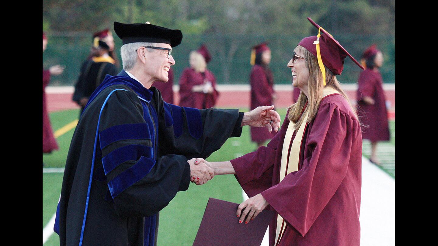 Superintendent and President of Glendale Community College David Viar, who shakes the hand of every graduate, embraces Lyn Ribisi after she graduated at Glendale Community College's graduation ceremony on Wednesday, June 8, 2016.