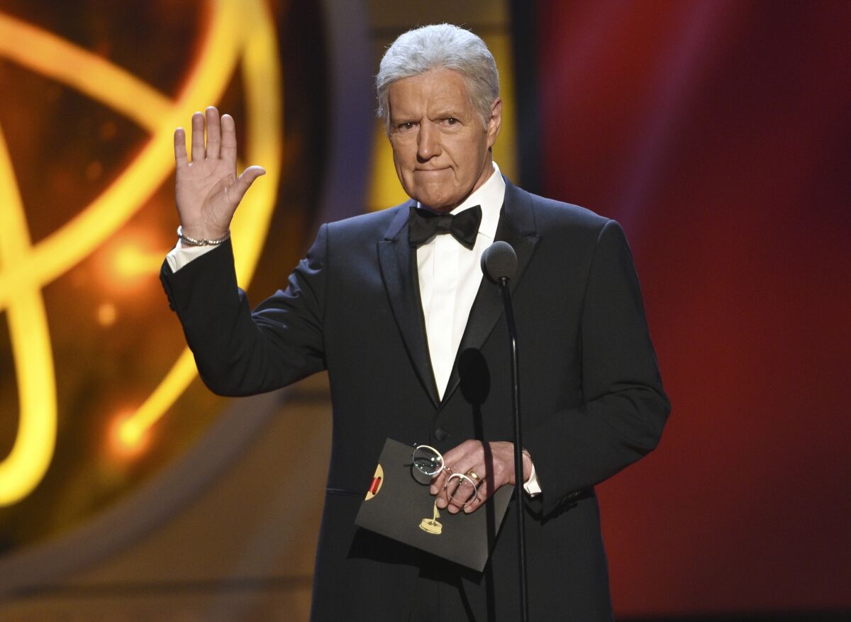 FILE - This May 5, 2019, file photo shows Alex Trebek gestures while presenting an award at the 46th annual Daytime Emmy Awards in Pasadena, Calif. Jeopardy!” host Alex Trebek died Sunday, Nov. 8, 2020, after battling pancreatic cancer for nearly two years. Trebek died at home with family and friends surrounding him, “Jeopardy!” studio Sony said in a statement. Trebek presided over the beloved quiz show for more than 30 years. (Photo by Chris Pizzello/Invision/AP, File)