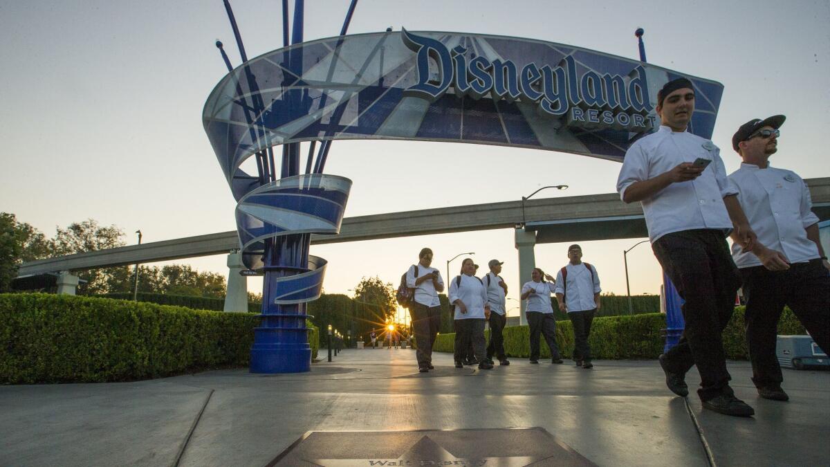 A Disney spokeswoman called the senators' letter calling for a living wage “political theater” and noted that the company in May offered a 36% pay increase over a three-year span for thousands of employees. Above, employees leave Disneyland.