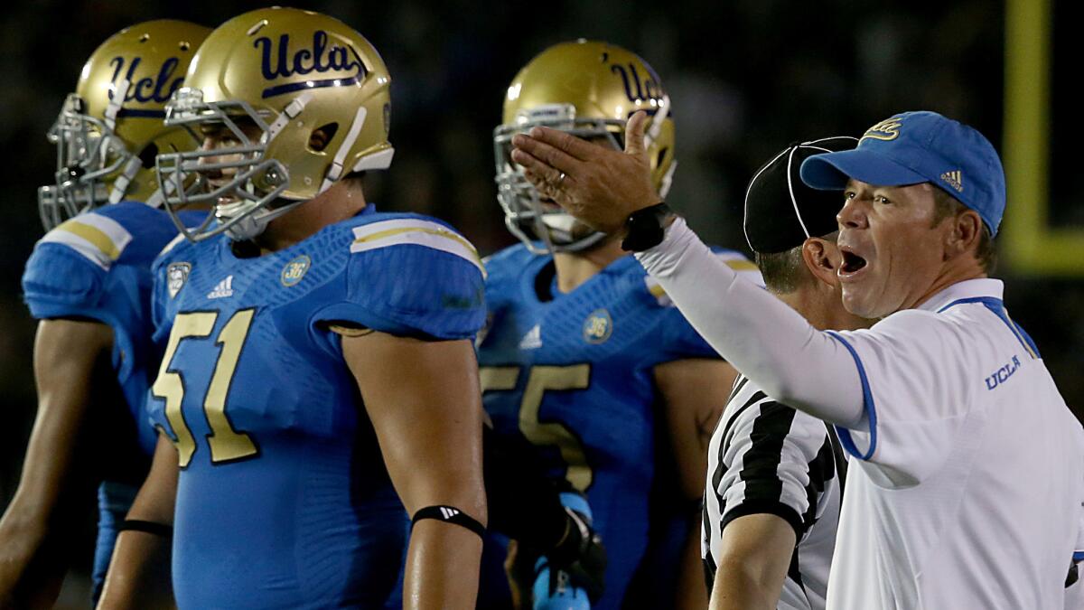 UCLA Coach Jim Mora directs offensive guard Alex Redmond, left, and other Bruins players during a game against California on Oct. 12, 2013.