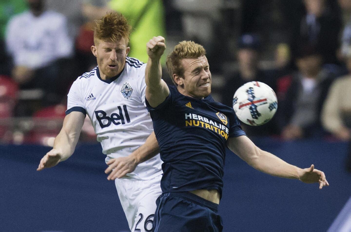 Vancouver Whitecaps' Tim Parker, left, and LA Galaxy's Jack McBean vie for the ball during the first half of an MLS soccer match Saturday, April 1, 2017, in Vancouver, British Columbia. (Darryl Dyck/The Canadian Press via AP)