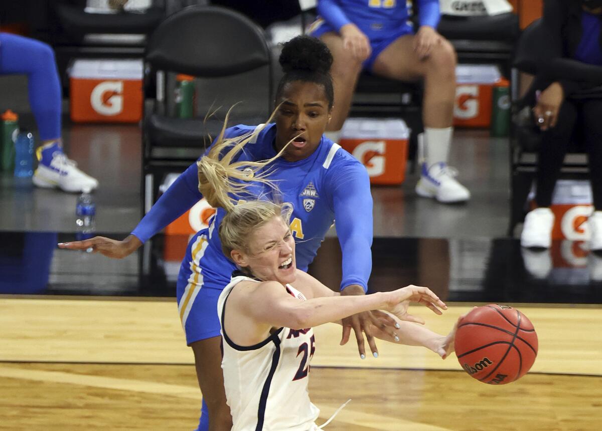 UCLA forward Lauryn Miller (33) and Arizona forward Cate Reese (25) fight for control of the ball during the first half of an NCAA college basketball game in the semifinals of the Pac-12 women's tournament Friday, March 5, 2021, in Las Vegas. (AP Photo/Isaac Brekken)