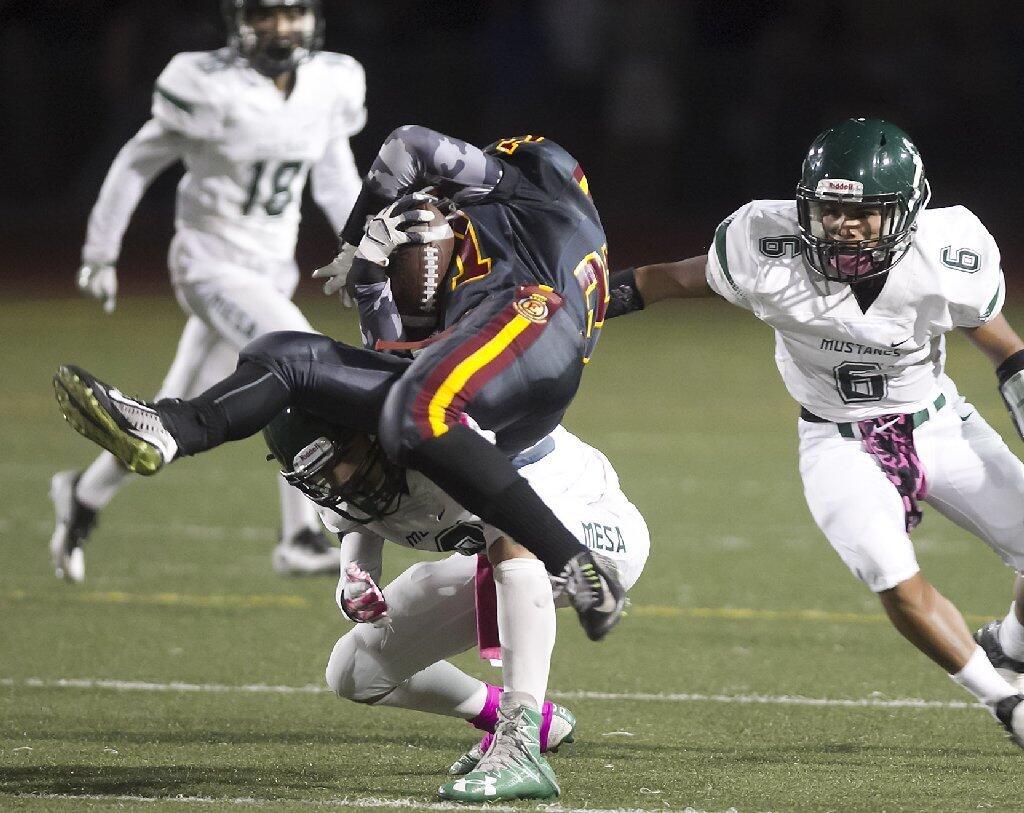 Estancia High's Jordan Balcazar is hit by Costa Mesa's Justin Figueroa on Friday.