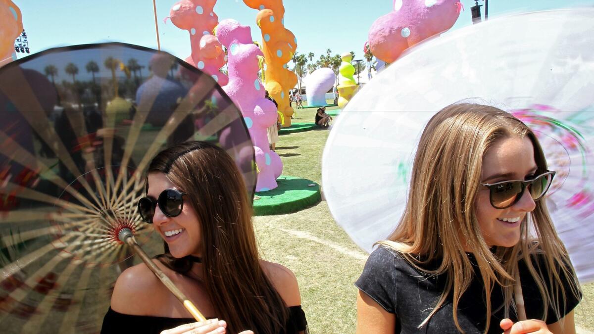 Madelyn Maresca, 21, and Kaitlin Mason, 21, stroll through a work of art called "Chiaozza Garden" on Friday, Day One of the Coachella Valley Music and Arts Festival in Indio.
