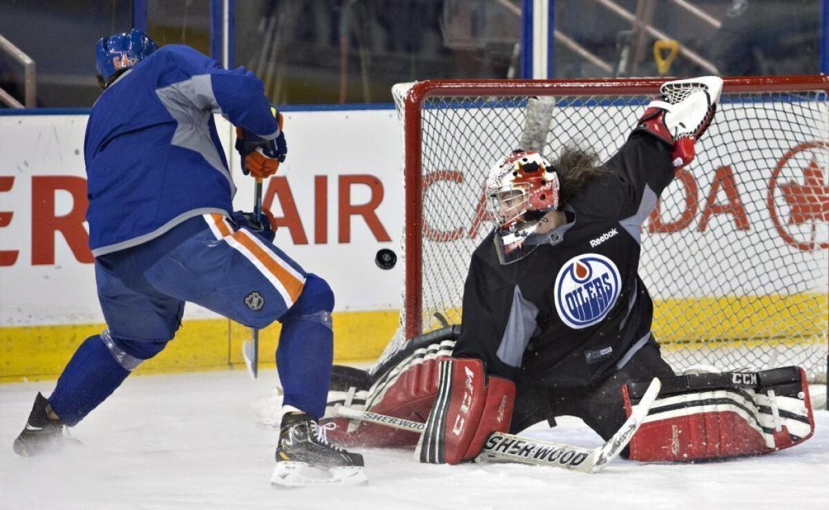 Shannon Szabados makes a save on Nail Yakupov during practice for the Edmonton Oilers.