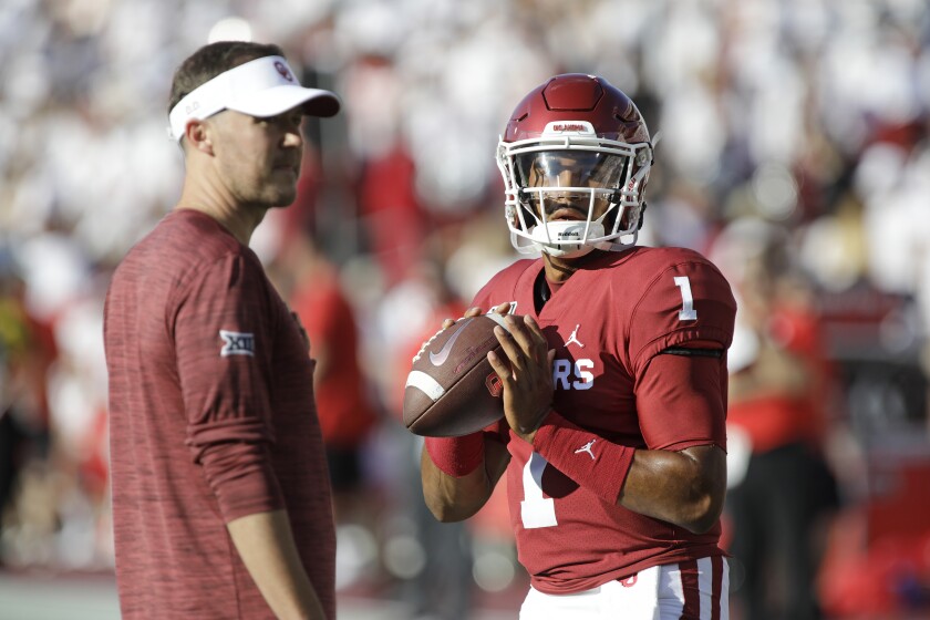 NORMAN, OK - SEPTEMBER 01: Quarterback Jalen Hurts #1 warms up while head coach Lincoln Riley of the Oklahoma Sooners watches before the game against the Houston Cougars at Gaylord Family Oklahoma Memorial Stadium on September 1, 2019 in Norman, Oklahoma. The Sooners defeated the Cougars 49-31. (Photo by Brett Deering/Getty Images)