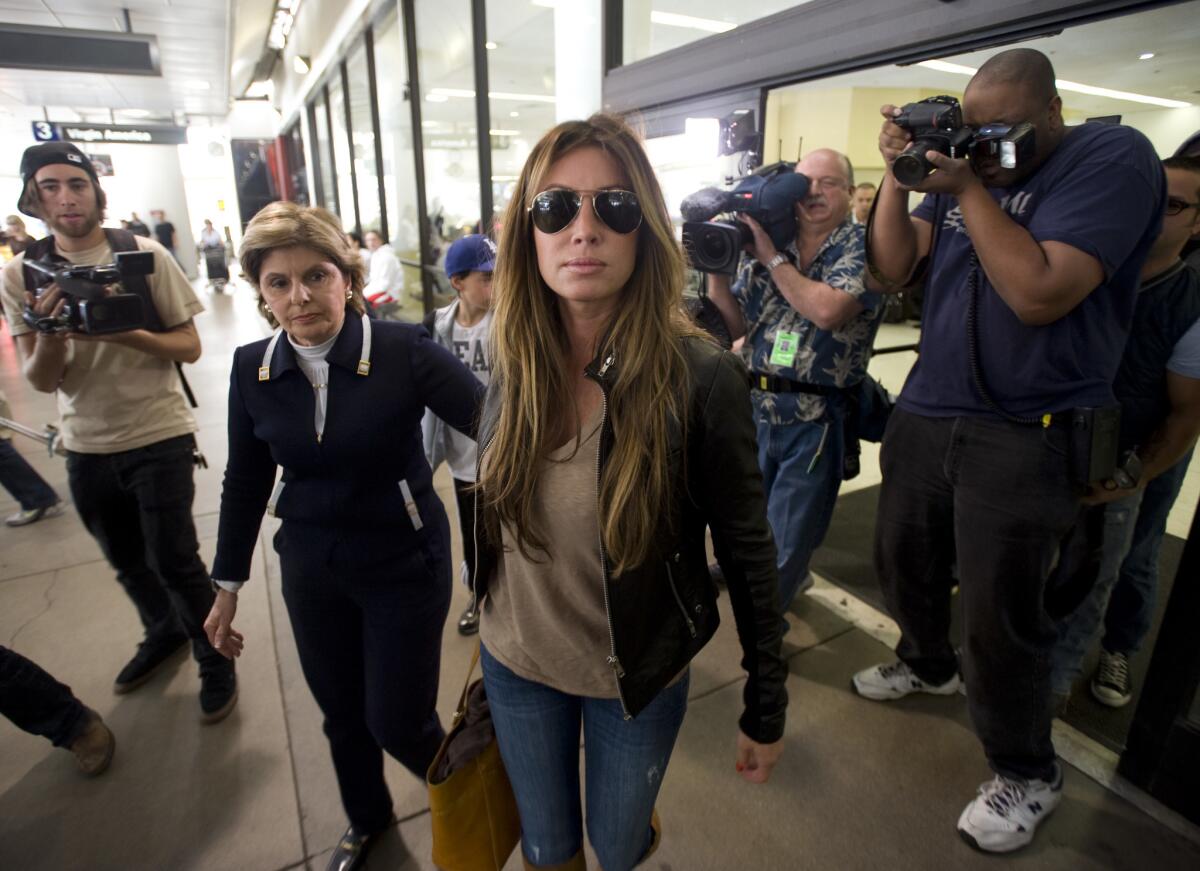 Rachel Uchitel is surrounded by paparazzi at LAX in 2009 alongside her lawyer, Gloria Allred.