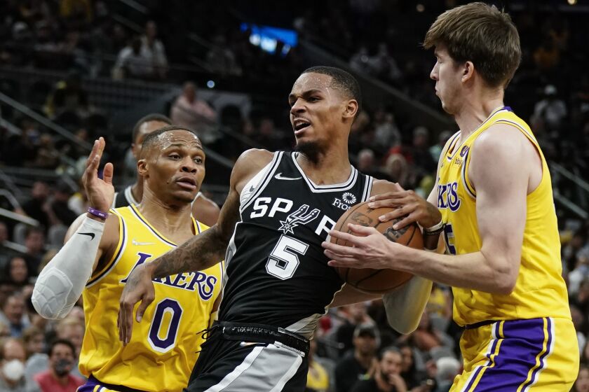 San Antonio Spurs' Dejounte Murray (5) tangles with Los Angeles Lakers' Russell Westbrook (0) and Austin Reaves during the first half of an NBA basketball game on Tuesday, Oct. 26, 2021, in San Antonio, Texas. (AP Photo/Darren Abate)