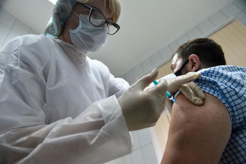 A nurse inoculates volunteer Ilya Dubrovin, 36, with Russia's new coronavirus vaccine in a post-registration trials at a clinic in Moscow on September 10, 2020. - Russia announced last month that its vaccine, named "Sputnik V" after the Soviet-era satellite that was the first launched into space in 1957, had already received approval. The vaccine was developed by the Gamaleya research institute in Moscow in coordination with the Russian defence ministry. (Photo by Natalia KOLESNIKOVA / AFP) (Photo by NATALIA KOLESNIKOVA/AFP via Getty Images)