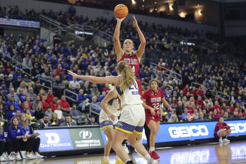 South Dakota center Hannah Sjerven (34) shoots over South Dakota State defenders during the championship game of the Summit League NCAA women's college basketball tournament on Tuesday, March 8, 2022, in Sioux Falls, S.D. (AP Photo/Josh Jurgens)