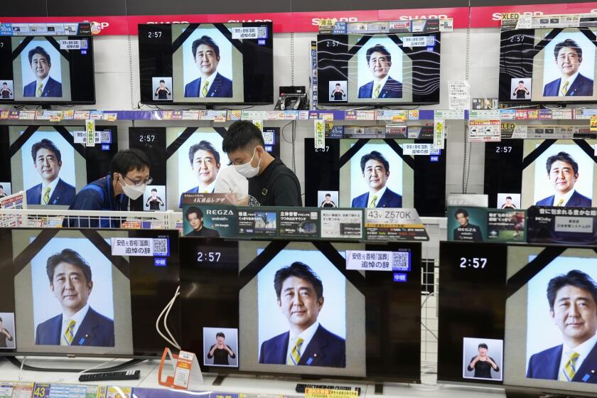 TV screens show the news programs reporting the state funeral for former Japanese Prime Minister Shinzo Abe, in Fukuoka, western Japan, on Tuesday, Sept. 27, 2022. (Kyodo News via AP)