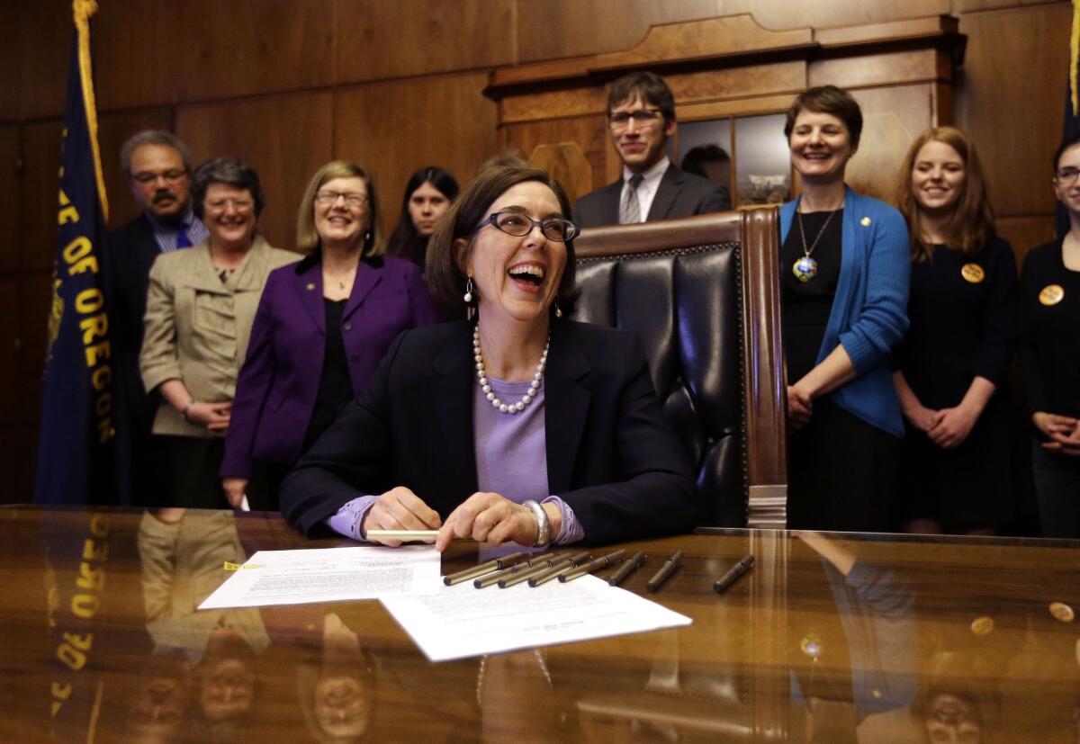 Oregon Gov. Kate Brown smiles after signing an automatic voter registration bill on March 16 in Salem, Ore.