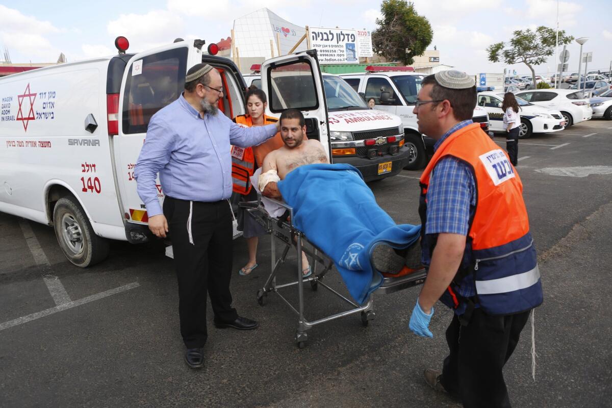 Israeli medics wheel a man wounded in a shooting in the West Bank as he is brought to a hospital in Tel Aviv on Friday.