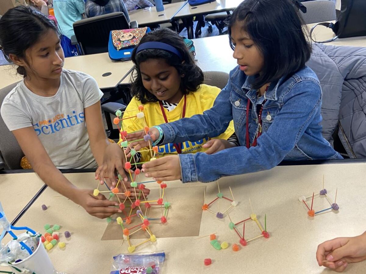 Project Scientist participants Thasya Muddana, Cheryll Prabakaran and Aleena Thomas, from left, try to build the tallest gummy tower during a visit to UC Irvine's engineering school Feb. 17.