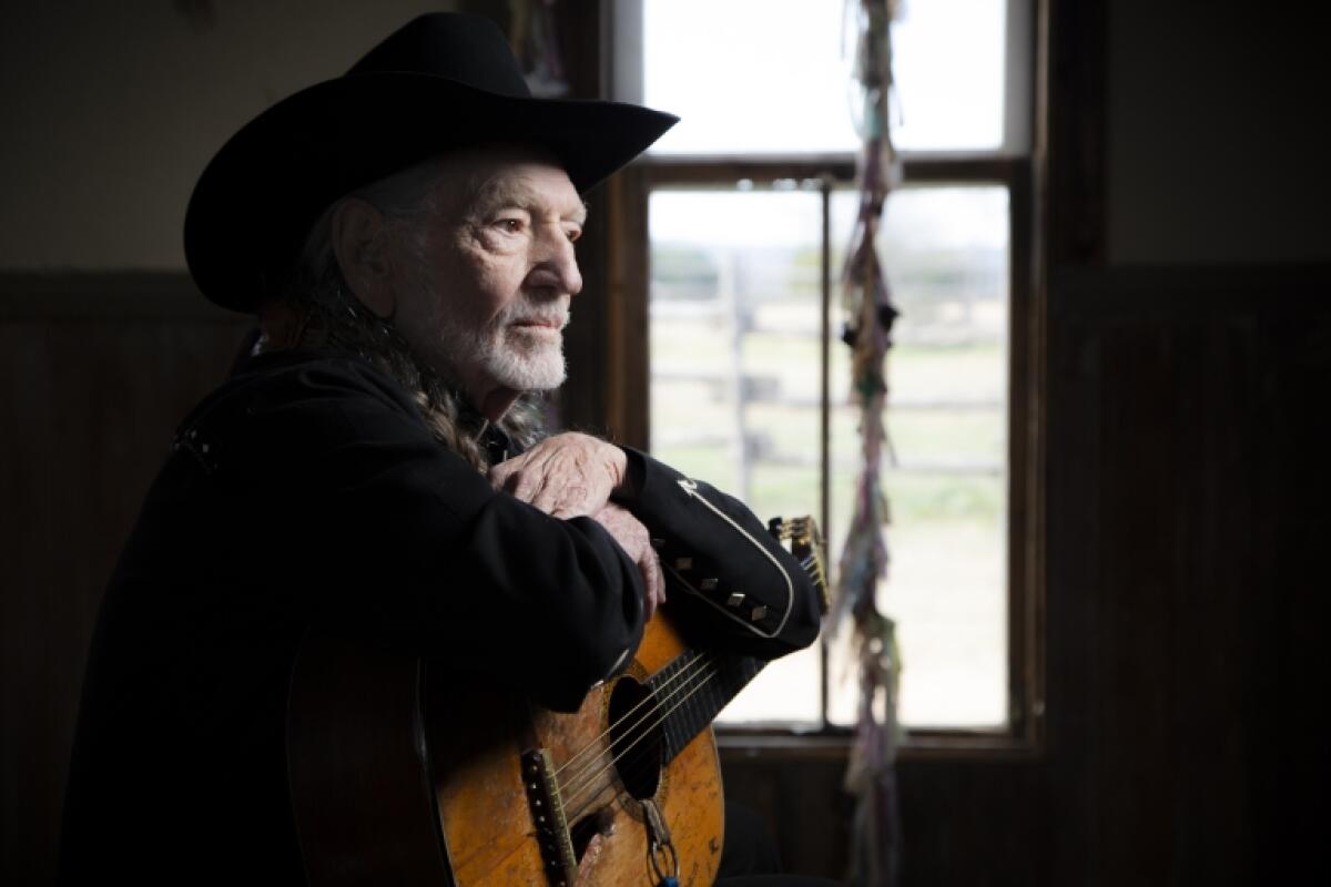 Willie Nelson is photographed beside a window.
