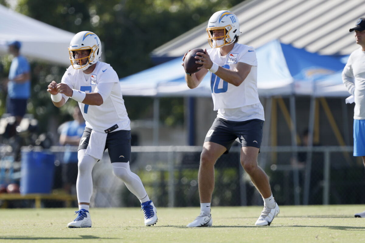 Chargers quarterbacks Justin Herbert (10) and Chase Daniel (7) work on drills.