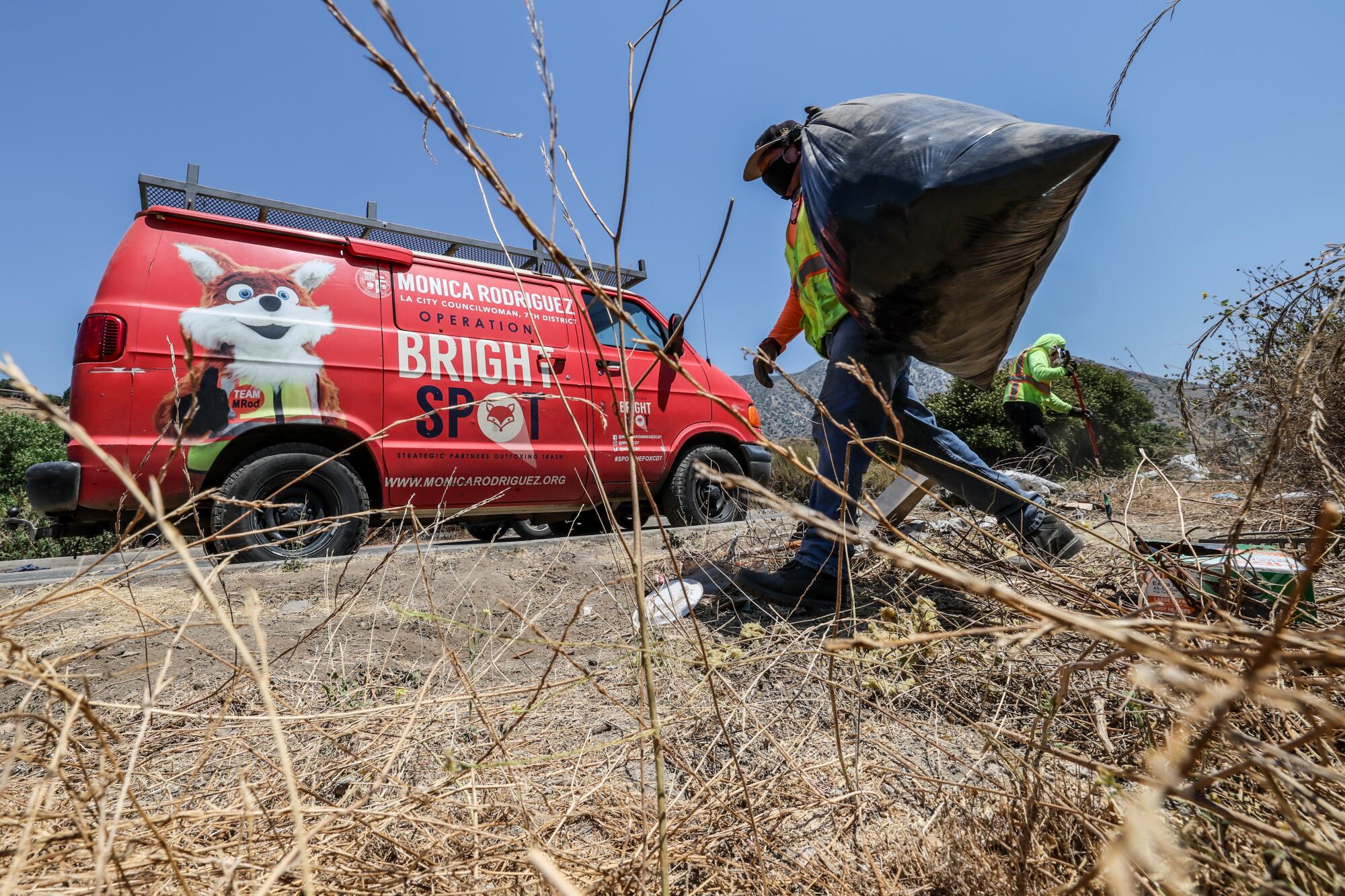 Workers with Operation Bright Spot clean trash from the Tujunga Wash.