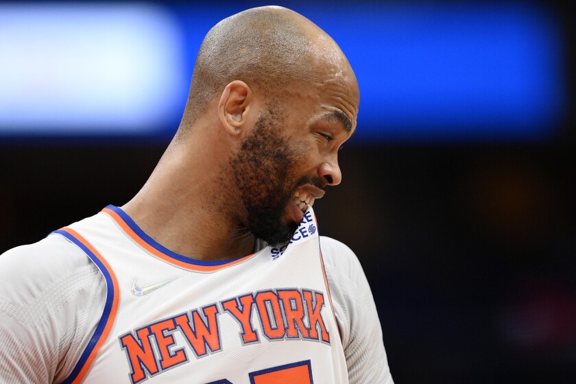 New York Knicks center Taj Gibson bites his jersey during the first half of the team's NBA basketball game against the Washington Wizards, Friday, April 8, 2022, in Washington. (AP Photo/Nick Wass)