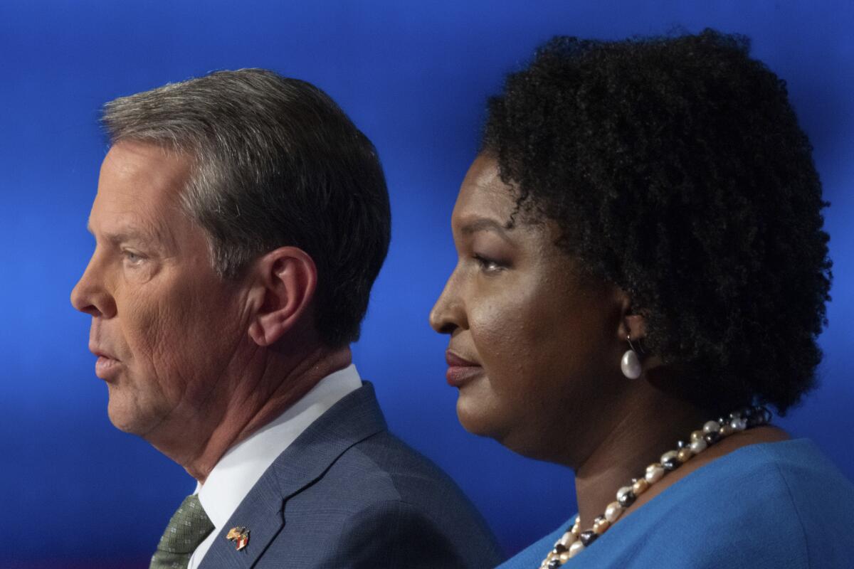 Brian Kemp and Stacey Abrams seen in profile, side by side.