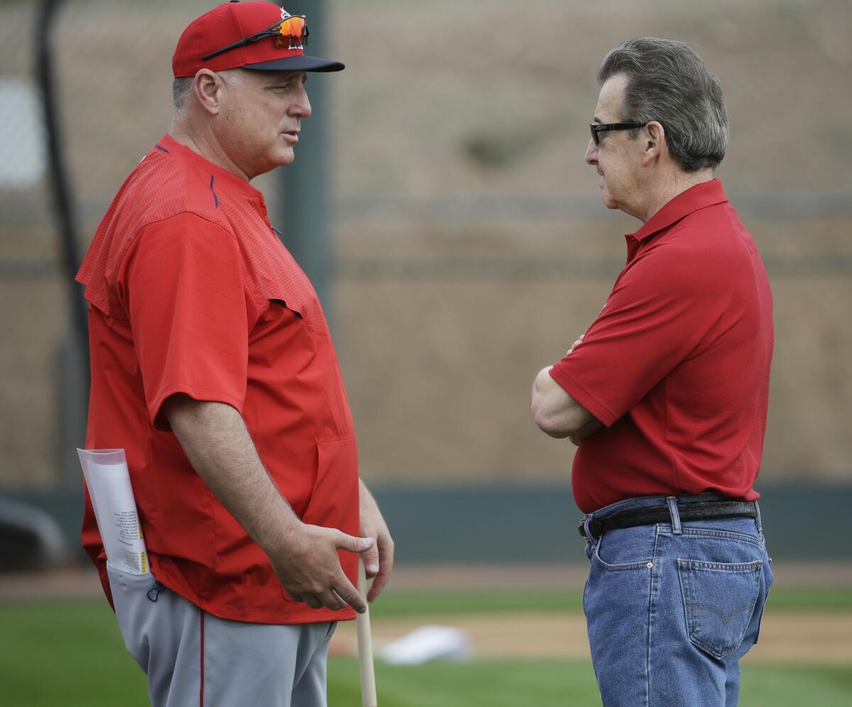 Angels Manager Mike Scioscia, left, and owner Arte Moreno talk during a spring training workout Tuesday in Tempe, Ariz.