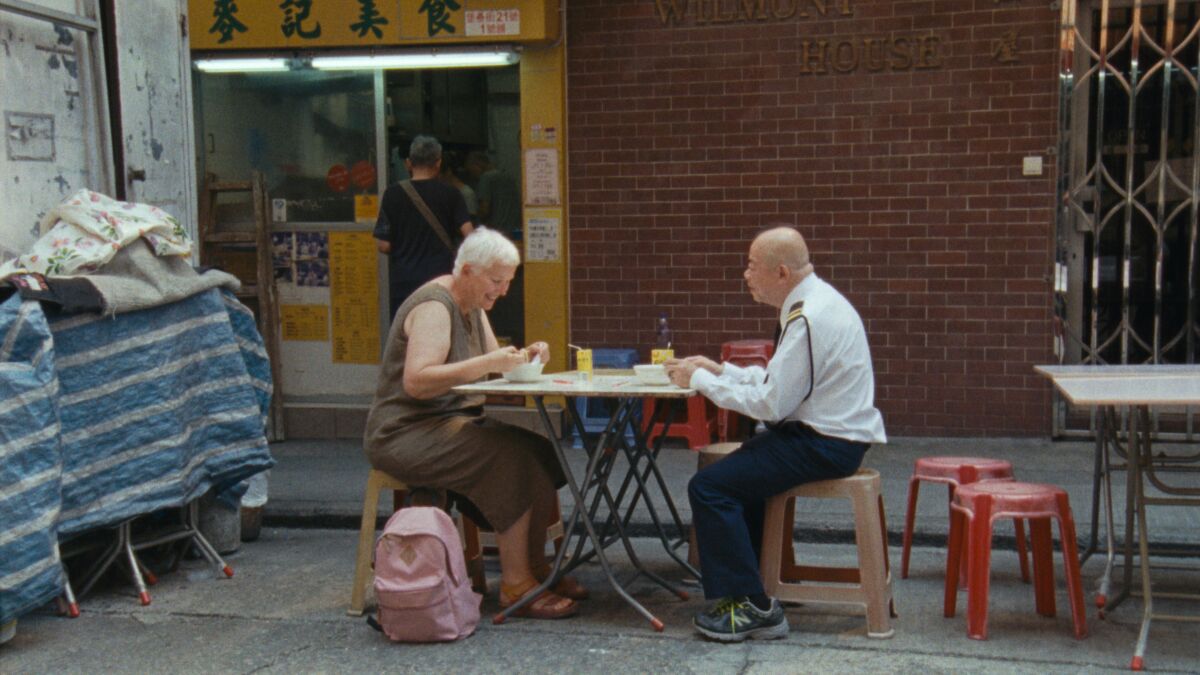 A woman and a man share a meal at an outdoor cafe in the movie "Wood and Water."