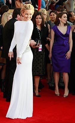 Kate Hudson's slinky white jersey, long-sleeved Emilio Pucci gown looked demure in the front, but was Jennifer Lopez-low in the back.