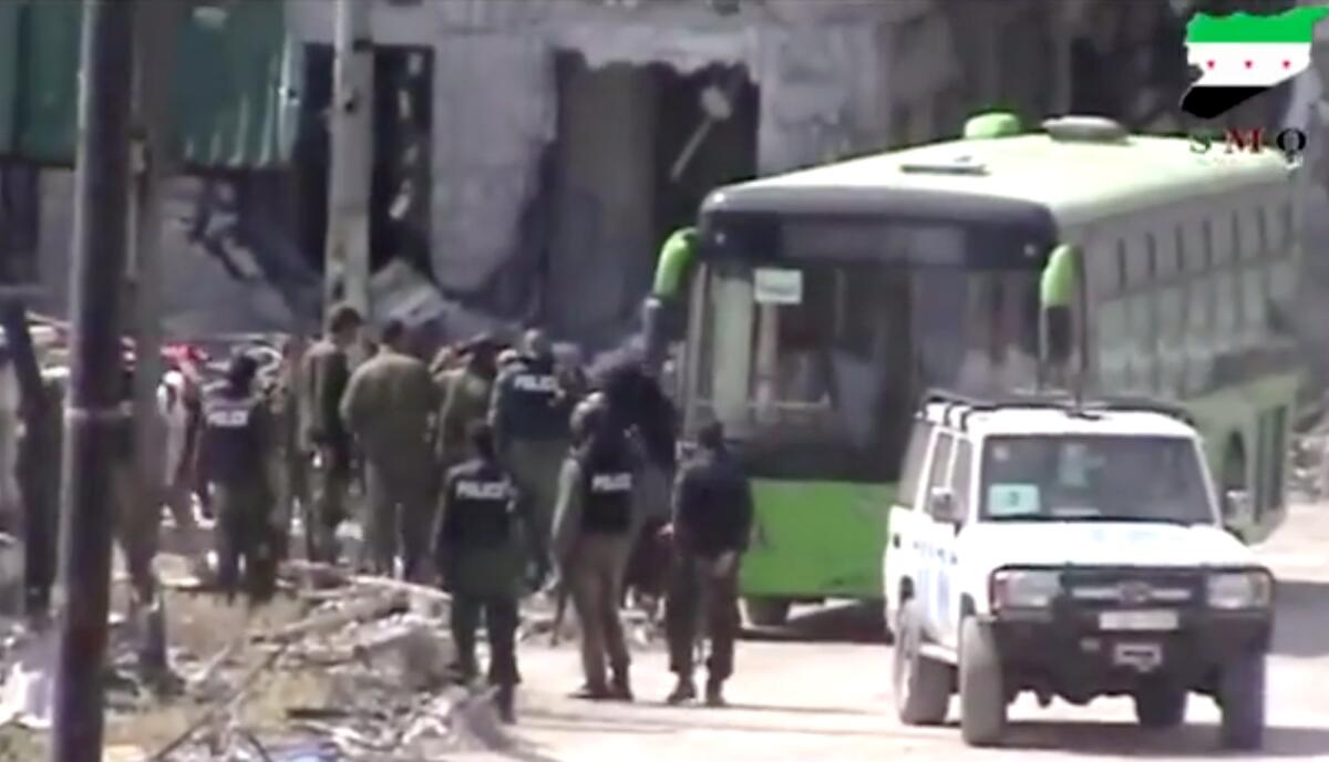 Syrian rebels board a bus to leave the Old City of Homs, in an image taken from amateur video.