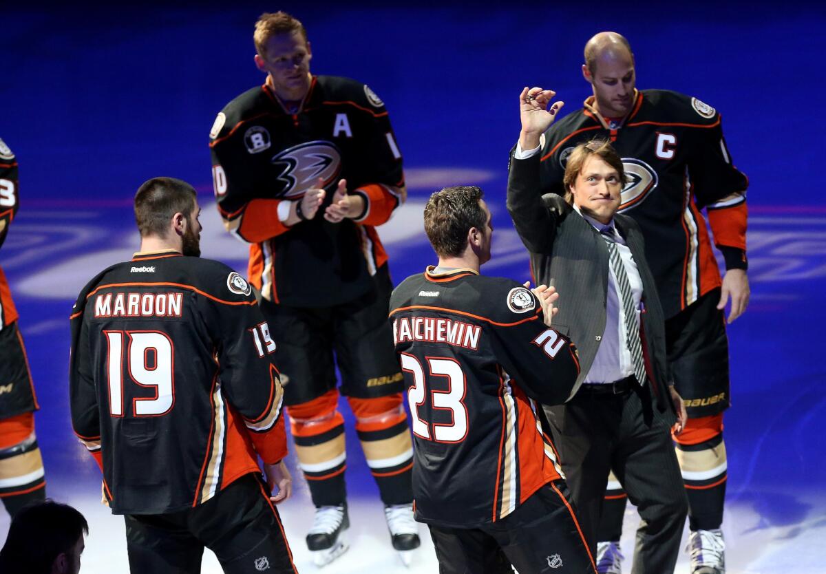 Former Ducks star Teemu Selanne waves to the Honda Center crowd as he walks through a line of former teammates during a jersey retirement ceremony Sunday.