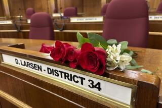 Roses rest on the Senate desk of late North Dakota Republican state Sen. Doug Larsen, at the state Capitol Monday, Oct. 2, 2023, in Bismarck, N.D. Larsen, his wife Amy, and their two young children died Sunday in a plane crash near Moab, Utah. Larsen was first elected to the state Senate in 2020. (AP Photo/Jack Dura)