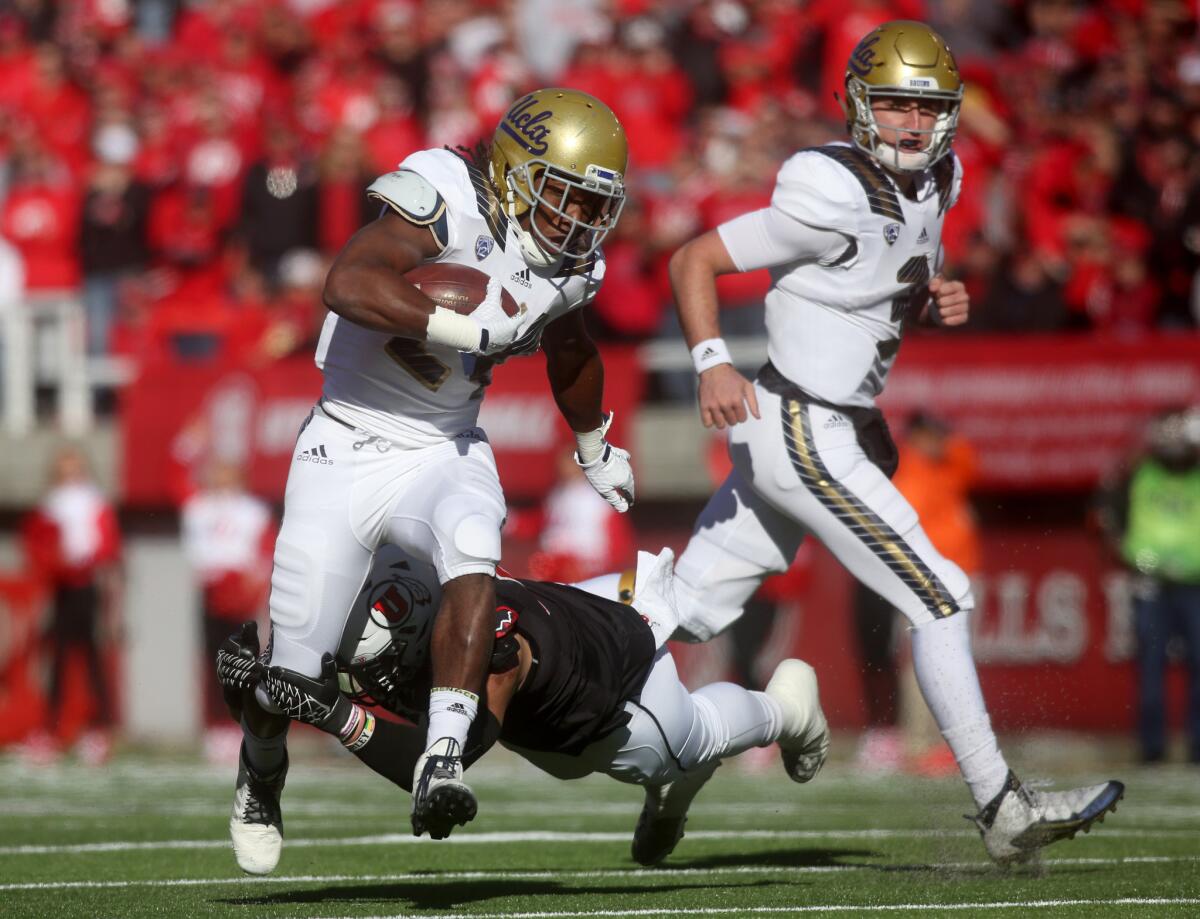 UCLA running back Paul Perkins tries to avoid the diving tackle attempt by Utah defensive end Jason Fanaika in the first half.