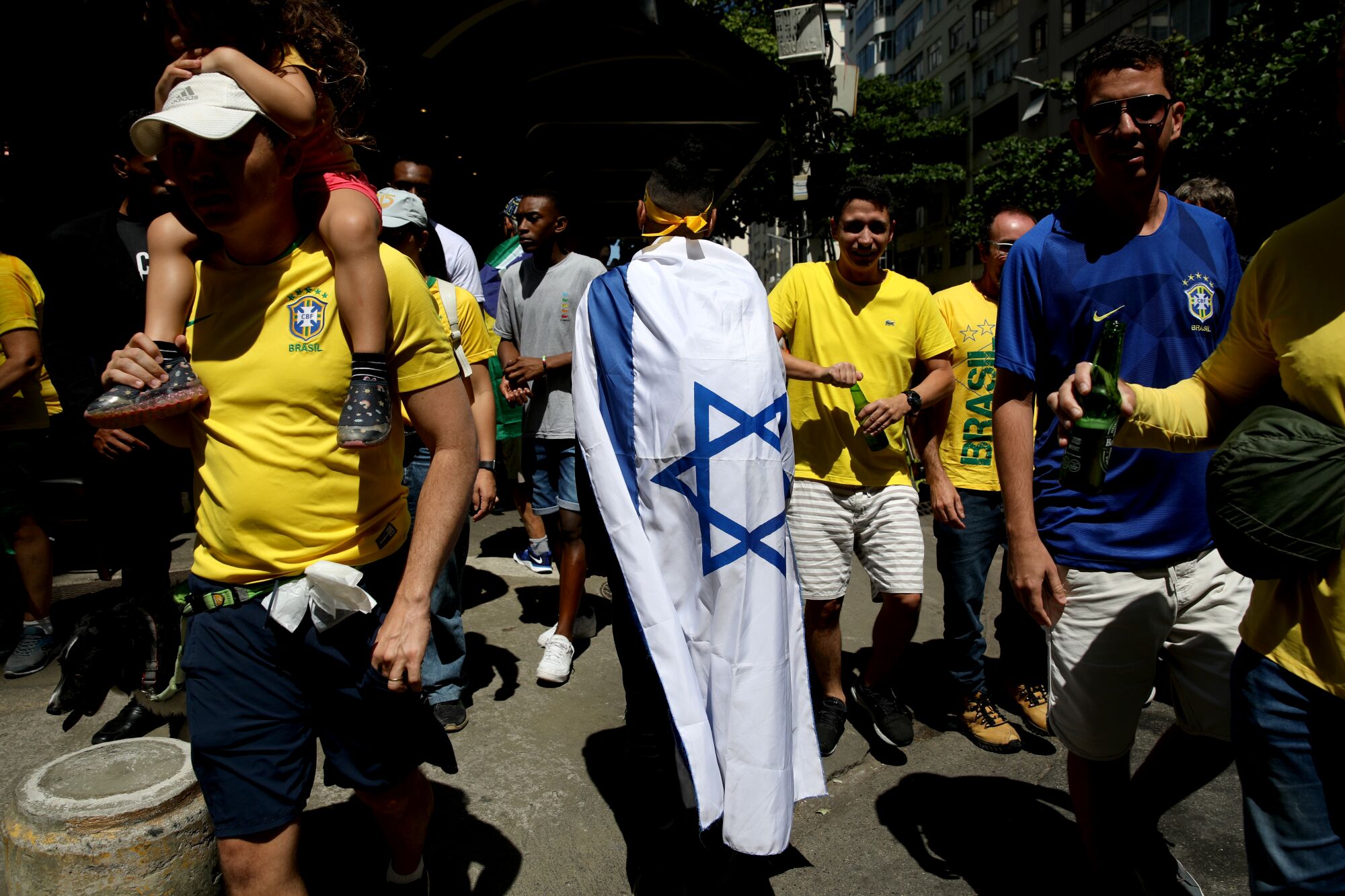 A man wears the flag of Israel at a rally.