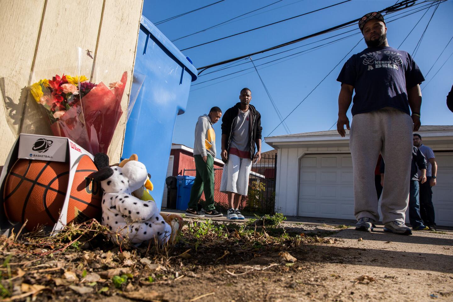 David Lee, 23, left, Antwan Burns-Jones, 31, and William Moore, 35, are among the neighbors who brought items Nov. 3, 2015, to remember Tyshawn Lee, 9, who was fatally shot in Chicago's Gresham neighborhood the day before.