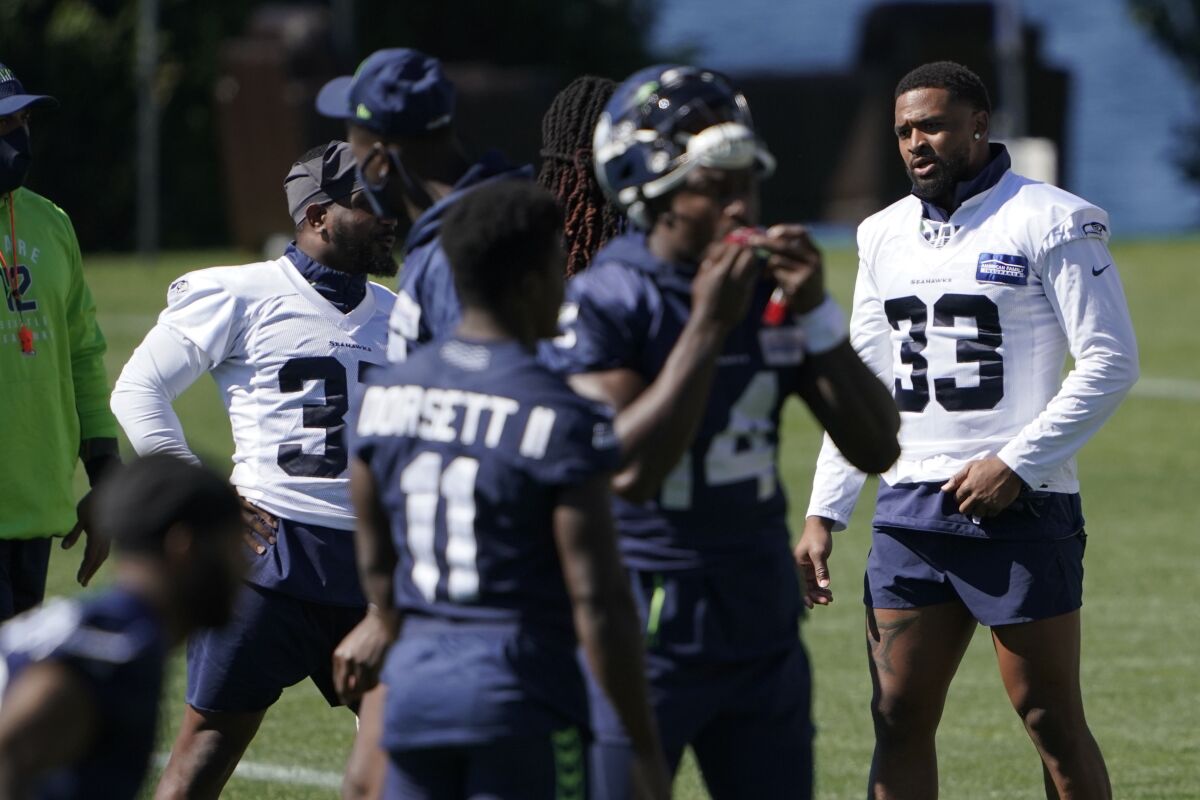 Seattle Seahawks safety Jamal Adams (33) stands on the field with teammates during NFL football training camp, Tuesday, Sept. 1, 2020, in Renton, Wash. (AP Photo/Ted S. Warren)