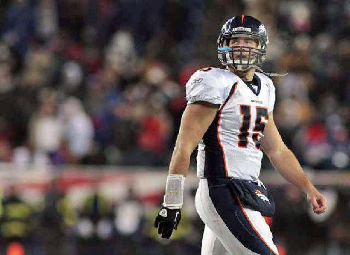 Tim Tebow walks off the field during the Broncos' playoff loss to New England.
