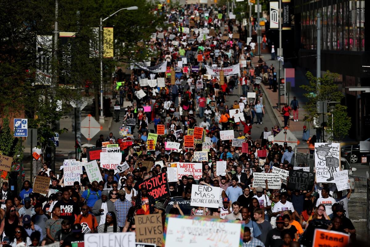 Protesters march from Baltimore City Hall on May 2, a day after the state's attorney filed charges against six police officers in connection with the death of Freddie Gray. The grand jury charges differ slightly from the original counts.