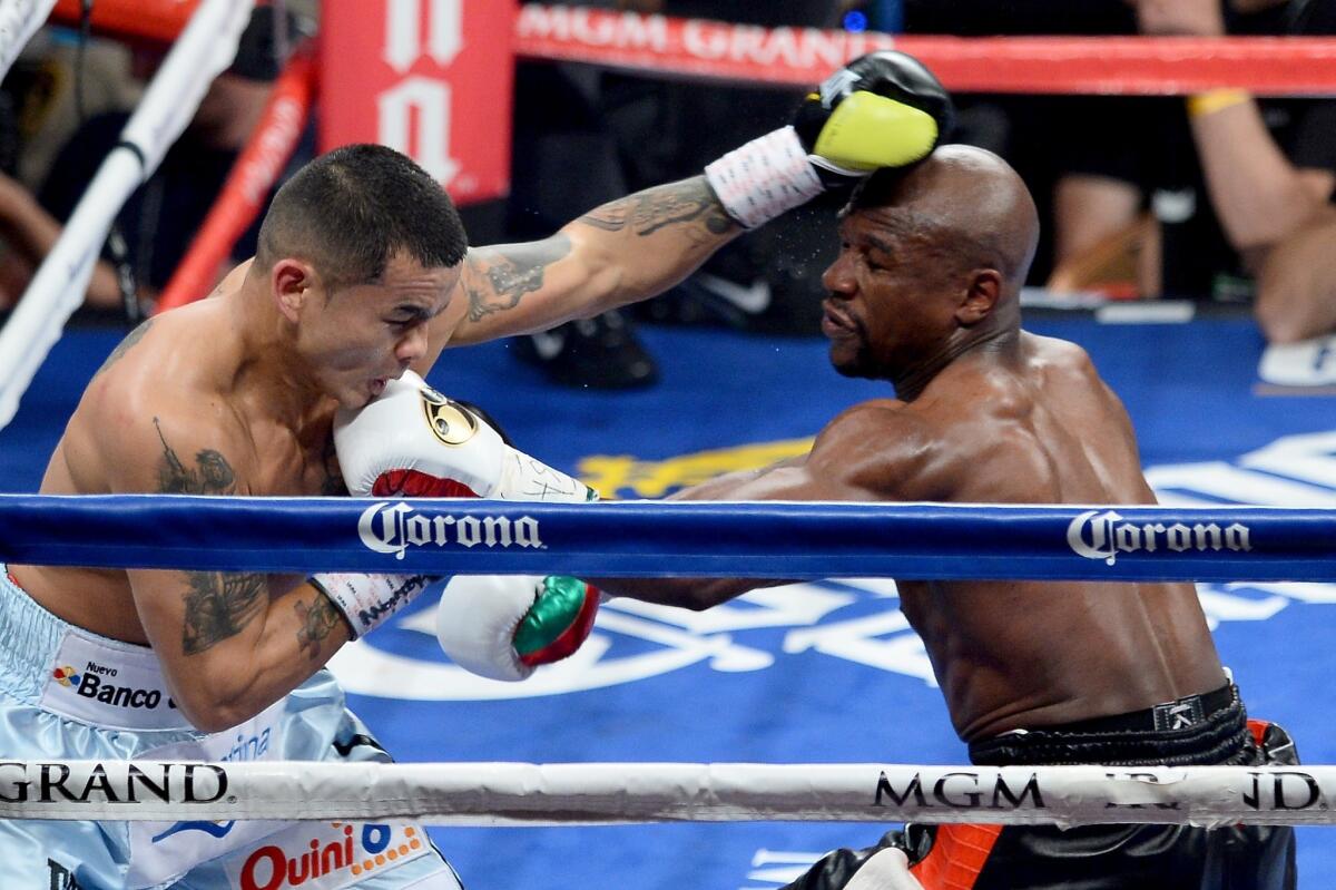 Floyd Mayweather Jr., right, exchanges blows with Marcos Maidana during their welterweight unification title fight in Las Vegas. Mayweather won by majority decision.