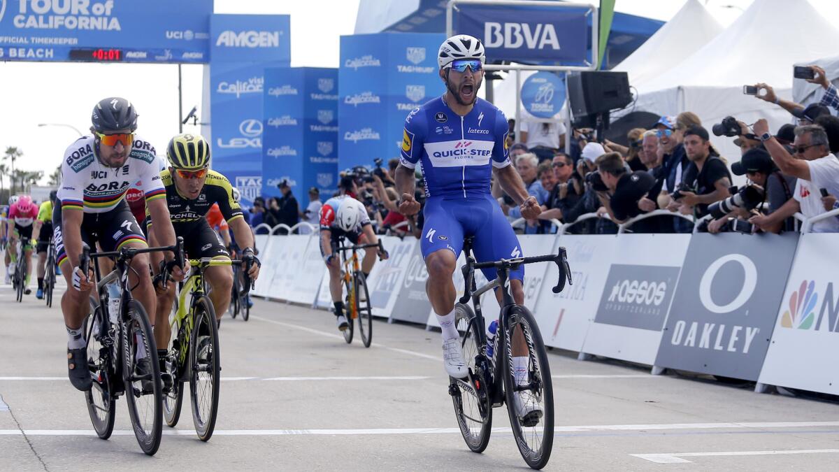 Fernando Gaviria celebrates after crossing the finish line to win the first stage of the Amgen Tour of California on Sunday in Long Beach.