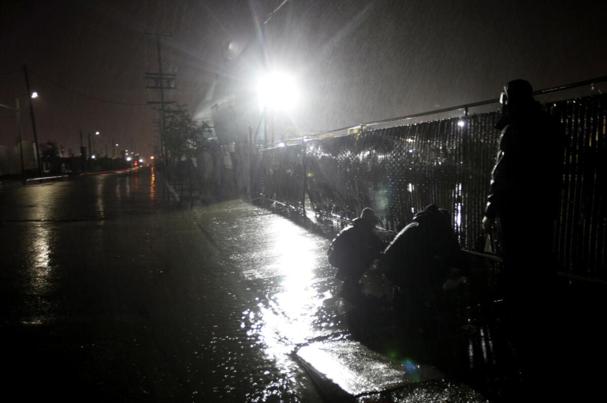 Lara Meeker, left, Michael Quill and Brian Meux, all with the environmental group Los Angeles Waterkeeper, are up very early to collect water samples of storm runoff from a waste transfer station in Sunland. The samples will later be tested for contaminants.