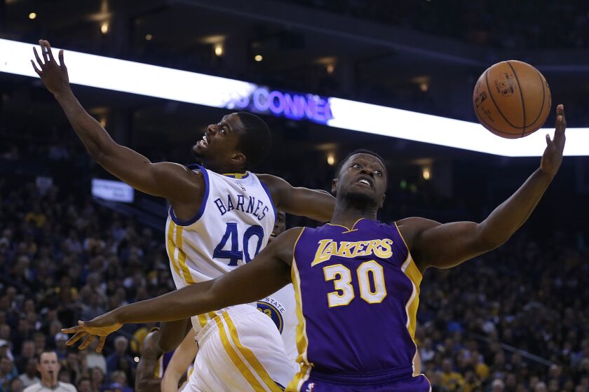 Los Angeles Lakers' Julius Randle, right, and Golden State Warriors' Harrison Barnes reach for a rebound during the first half on Thursday.