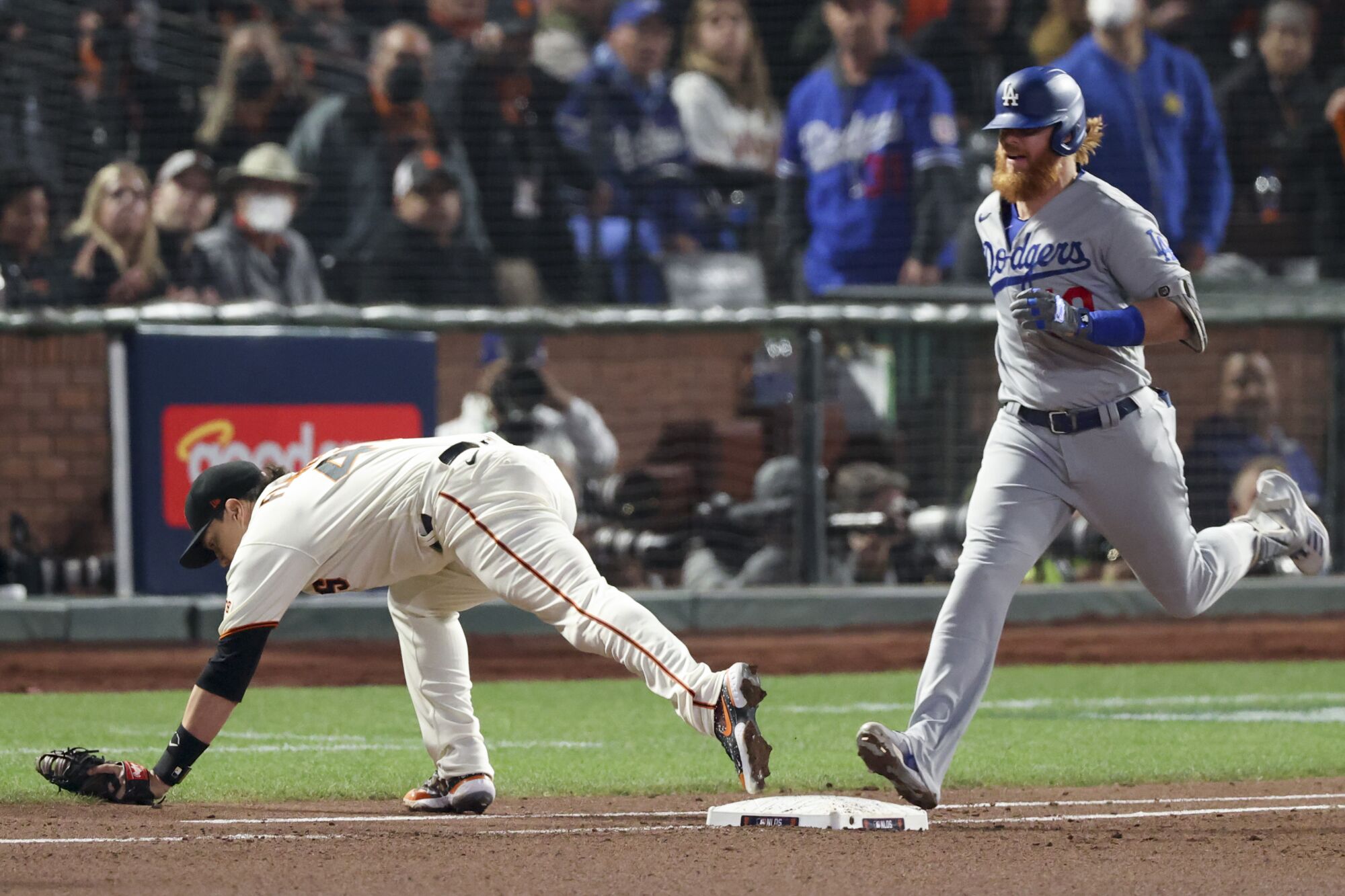 Giants first baseman Wilmer Flores, left, catches the ball to force out Dodgers' Justin Turner